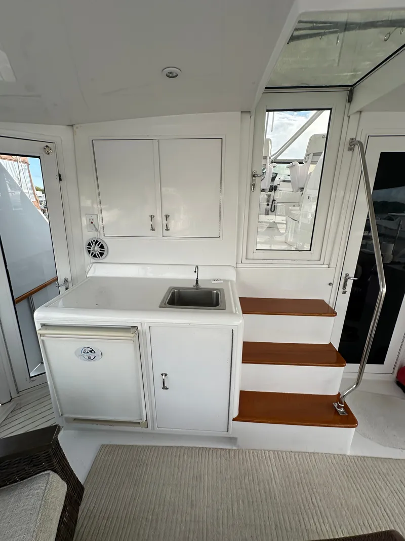 Slide: The Image of 1994 Hatteras 48 Cockpit MY interior with sink, cabinets, and stairs. - 9