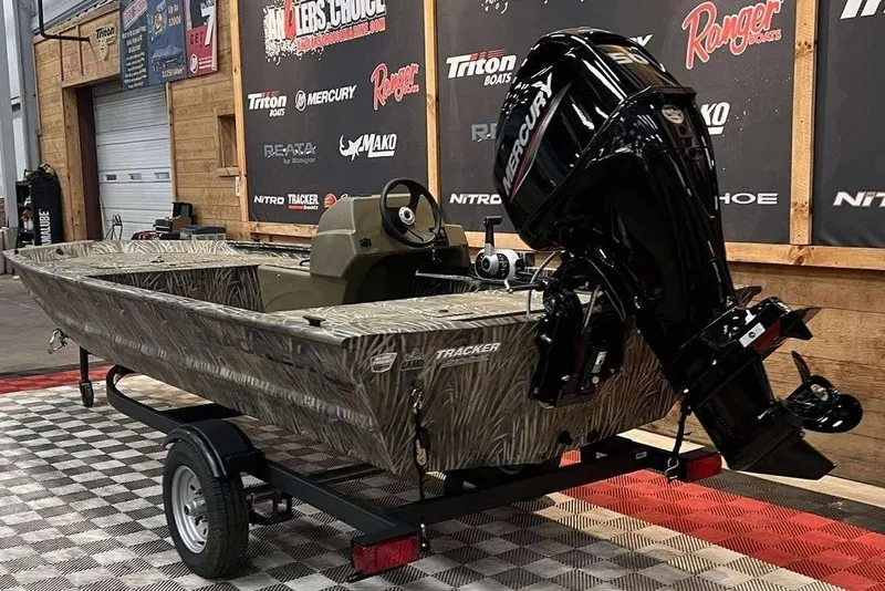 Slide: The Image of 2026 Tracker Grizzly 1648 SC boat with Mercury engine on display in showroom. - 3