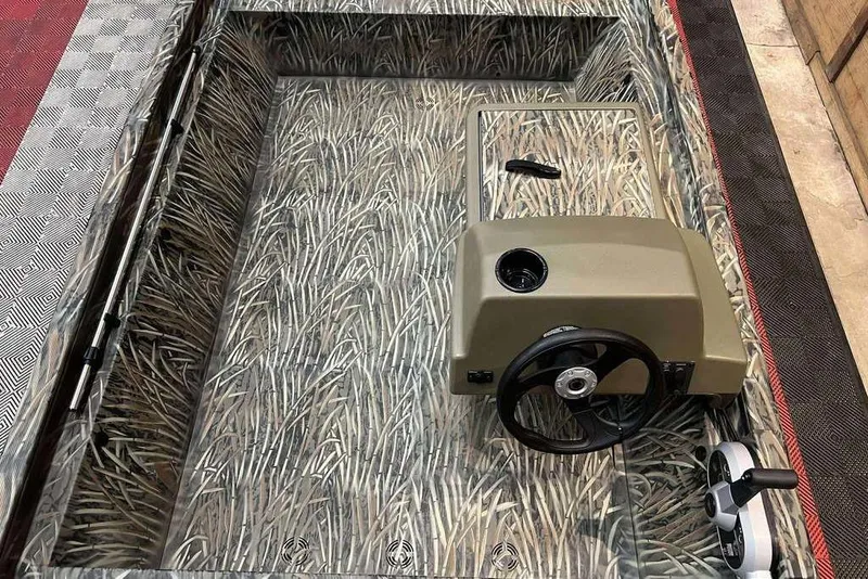 Slide: The Image of 2026 Tracker Grizzly 1648 SC boat interior with camouflage design and steering console. - 4