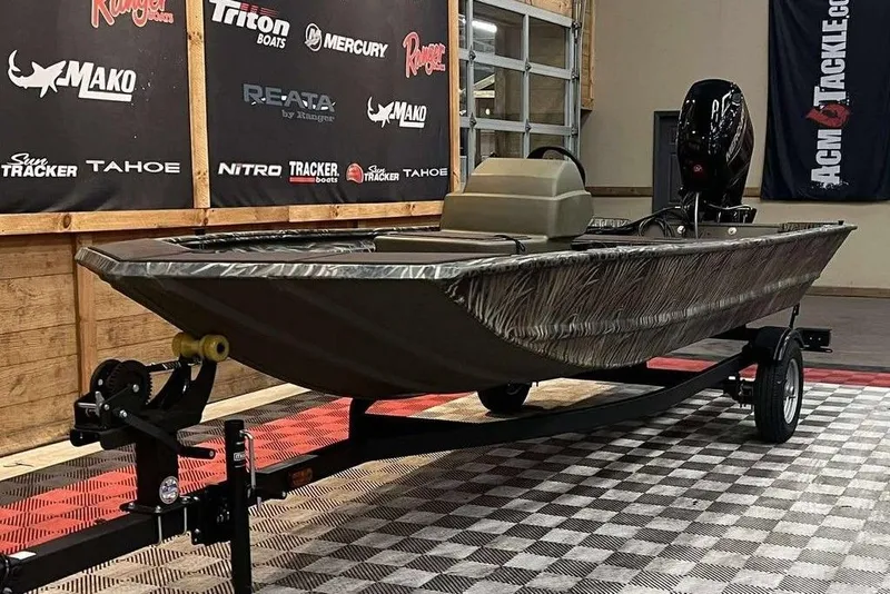 Slide: The Image of 2026 Tracker Grizzly 1648 SC boat on display in showroom with branded banners. - 6