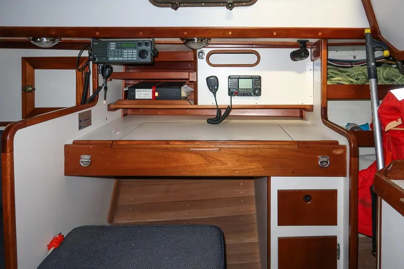 Slide: The Image of Navigation station inside 1989 Morris Ocean Series 32 sailboat, featuring radio equipment and wooden cabinetry. - 22