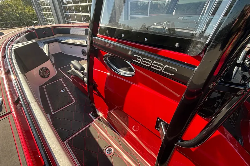 Slide: The Image of 2021 Fountain 38 SC boat interior with red and black design, featuring seating and speakers. - 12