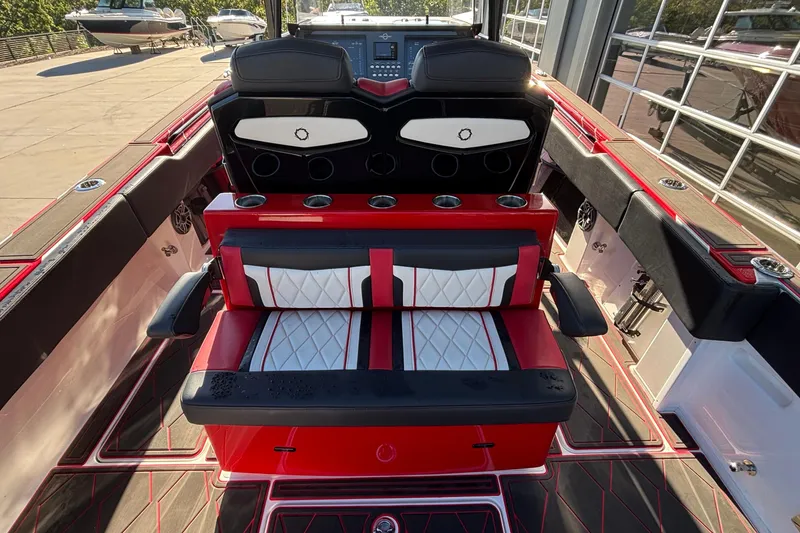 Slide: The Image of 2021 Fountain 38 SC boat interior with red and black seating, cup holders, and dashboard view. - 25