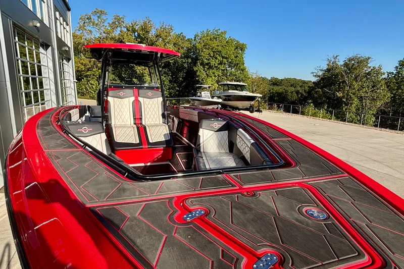 Slide: The Image of 2021 Fountain 38 SC boat with red and black detailing, parked outdoors. - 9