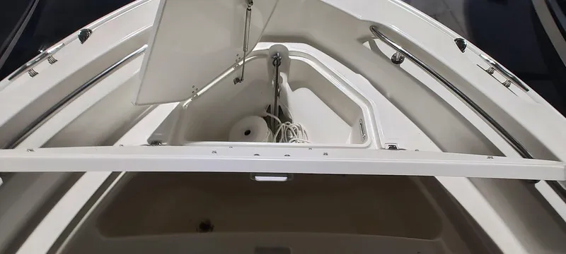Slide: The Image of 2023 Boston Whaler 220 Dauntless boat bow storage compartment with open hatch. - 16