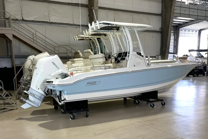 Slide: The Image of 2023 Boston Whaler 220 Dauntless boat in a warehouse setting. - 2