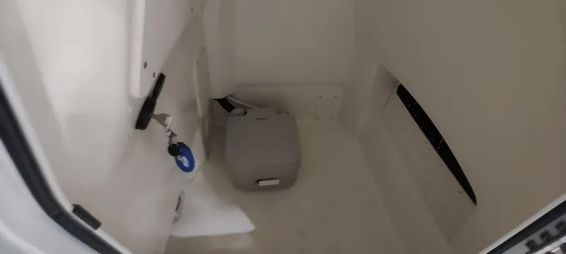 Slide: The Image of 2023 Boston Whaler 220 Dauntless interior storage compartment with key and container. - 20