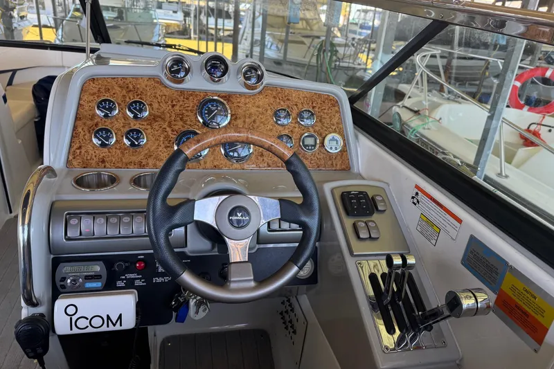 Slide: The Image of 2008 Formula 310 Bowrider dashboard with steering wheel, gauges, and controls in a marina setting. - 25