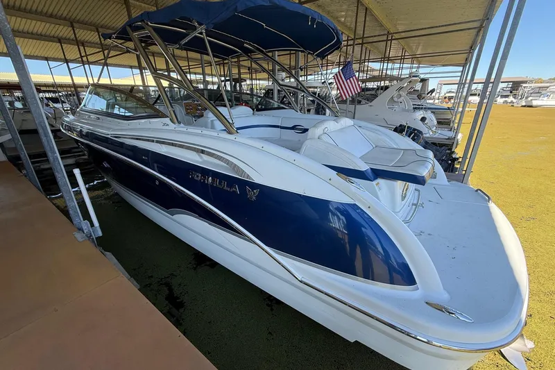 Slide: The Image of 2008 Formula 310 Bowrider boat docked under a covered marina. - 28