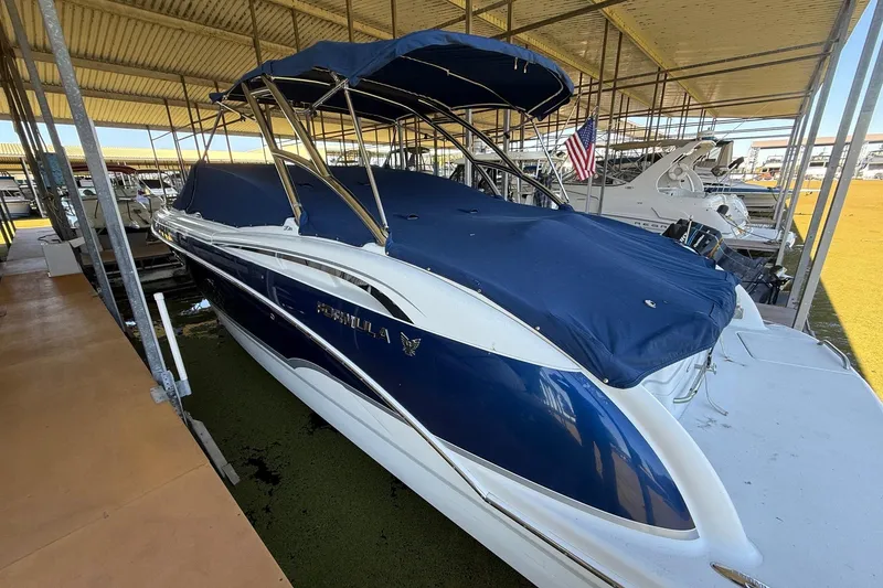 Slide: The Image of 2008 Formula 310 Bowrider boat with blue cover docked under shelter. - 32