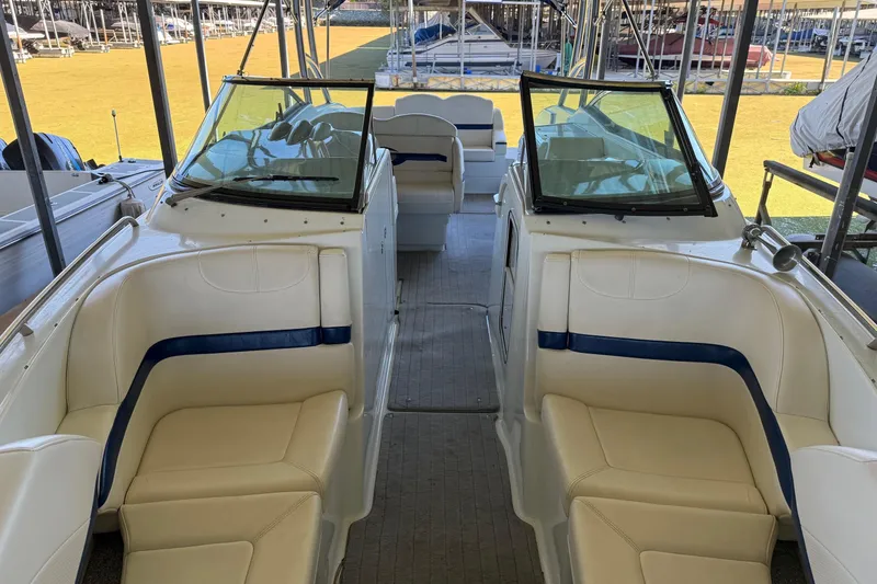 Slide: The Image of 2008 Formula 310 Bowrider interior with white and blue seating, docked in a marina. - 6