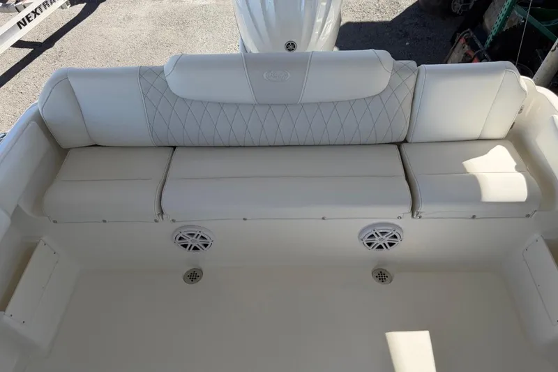Slide: The Image of 2026 Key West 239 FSR boat interior with white cushioned seating and built-in speakers. - 14