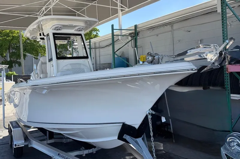 Slide: The Image of 2026 Key West 239 FSR boat on trailer under canopy, side view. - 2