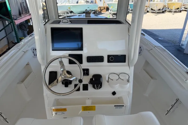 Slide: The Image of 2026 Key West 239 FSR boat dashboard with steering wheel and electronic controls. - 27