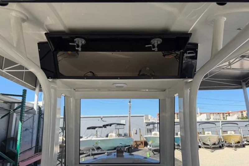Slide: The Image of 2026 Key West 239 FSR boat interior with overhead compartment, docked under a canopy. - 32