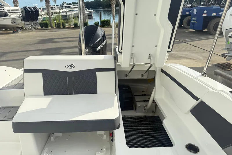 Slide: The Image of 2022 Monterey M-225 boat interior with seating and open storage compartment. - 11