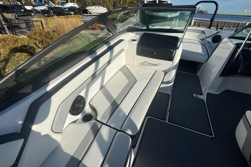 Slide: The Image of 2018 Yamaha Boats AR195 interior with seating and speaker, docked near water. - 10