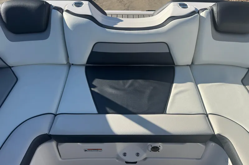 Slide: The Image of 2018 Yamaha Boats AR195 interior seating, featuring sleek white and black upholstery. - 16