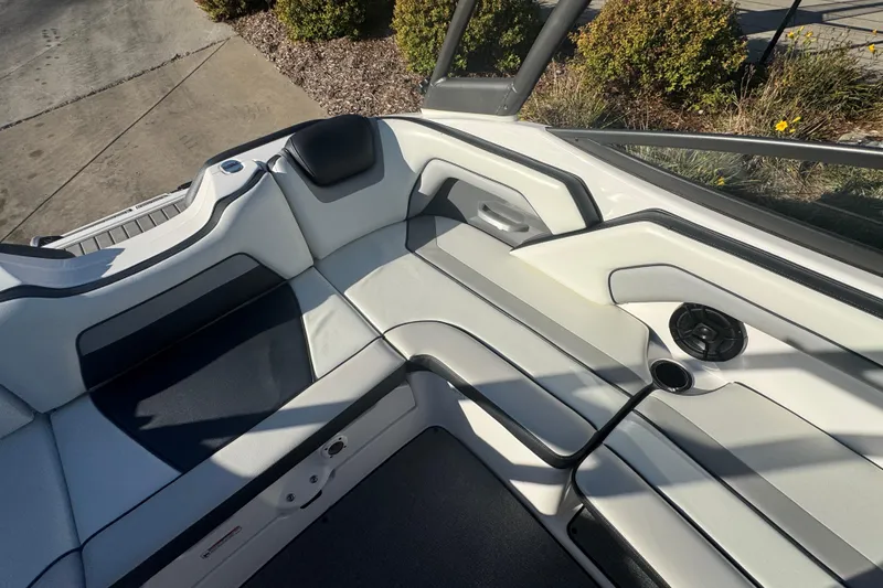 Slide: The Image of 2018 Yamaha AR195 boat interior with white and gray seating, speaker, and cup holder. - 9