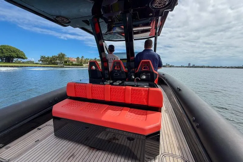 Slide: The Image of Luxury Skipper-BSK 42NC boat with red seating, cruising on a scenic waterway, 2023 model. - 13