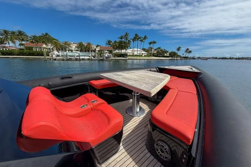 Slide: The Image of Luxurious 2023 Skipper-BSK 42NC yacht with red seating and wooden table, docked by palm trees. - 20