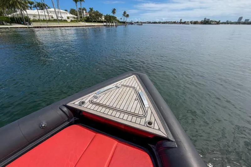 Slide: The Image of Bow of 2023 Skipper-BSK 42NC boat with red seating, on calm water. - 22