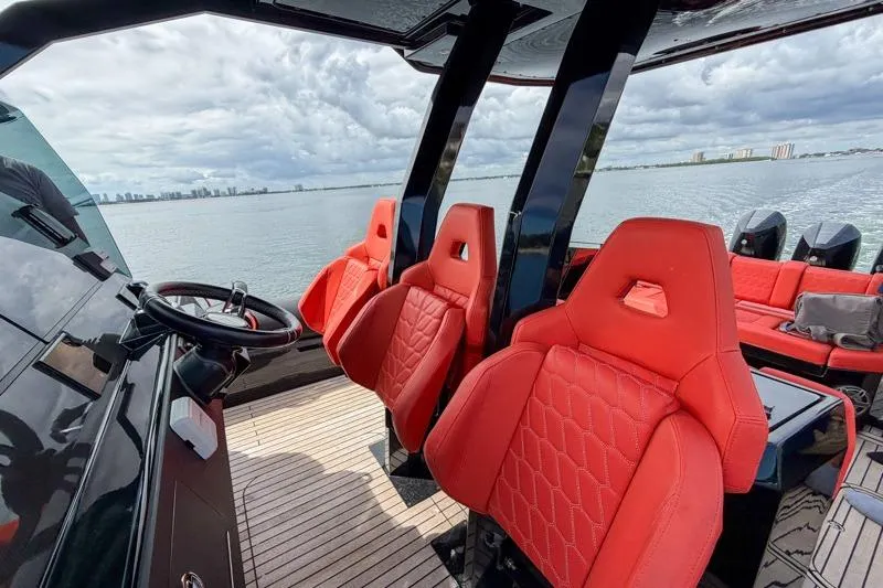 Slide: The Image of 2023 Skipper-BSK 42NC boat with red seats and scenic ocean view. - 26