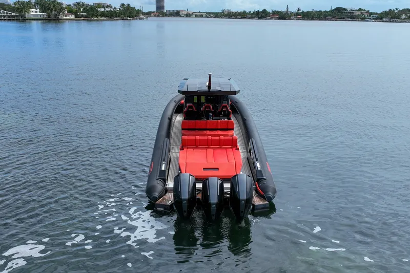 Slide: The Image of 2023 Skipper-BSK 42NC boat with red seating, docked on calm water. - 4