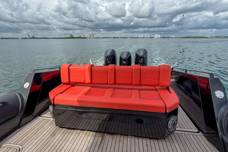 Slide: The Image of Luxury Skipper-BSK 42NC boat with red seating, cruising on open water under cloudy skies. - 5