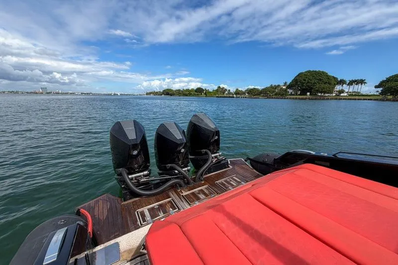 Slide: The Image of 2023 Skipper-BSK 42NC boat with triple engines and red seating on a sunny day. - 9