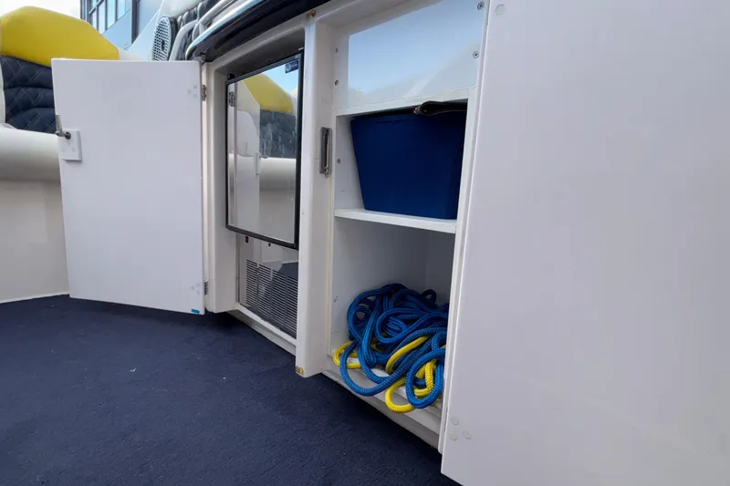 Slide: The Image of 2002 Donzi 45 ZX boat storage compartment with ropes and blue container. - 17