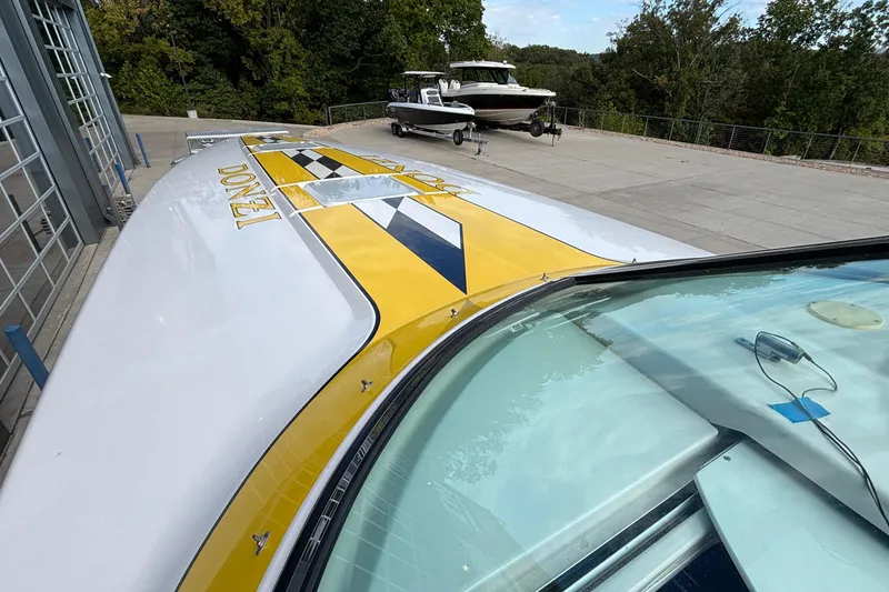 Slide: The Image of 2002 Donzi 45 ZX boat with yellow and black design, parked outdoors. - 26