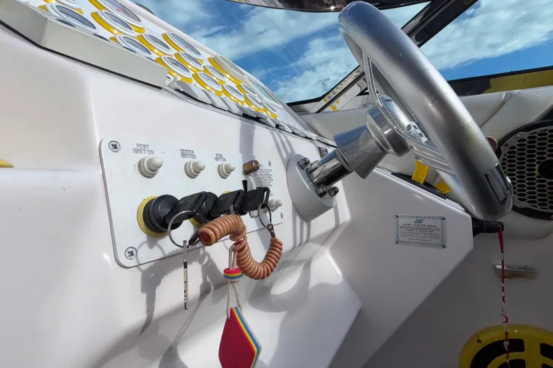 Slide: The Image of 2002 Donzi 45 ZX boat dashboard with steering wheel and ignition switches. - 41