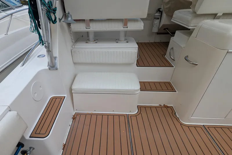 Slide: The Image of 2002 Stamas 340 Express boat interior with teak flooring and cushioned seating. - 11