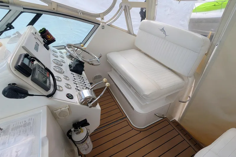 Slide: The Image of 2002 Stamas 340 Express boat cockpit with steering wheel, controls, and white seating. - 16