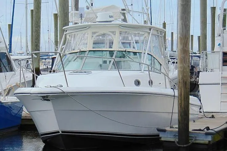 Slide: The Image of 2002 Stamas 340 Express boat docked at marina with clear skies. - 2