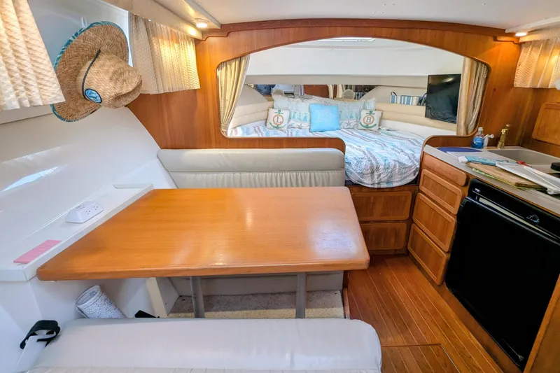 Slide: The Image of 2002 Stamas 340 Express cabin interior with dining area, bed, and kitchenette. - 23
