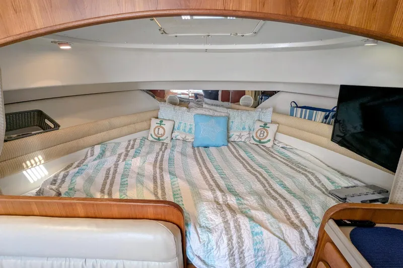 Slide: The Image of Cozy cabin interior of 2002 Stamas 340 Express with striped bedding and nautical decor. - 31