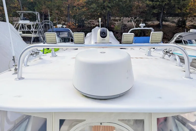 Slide: The Image of 2002 Stamas 340 Express boat deck with radar and lights, docked among other boats. - 40