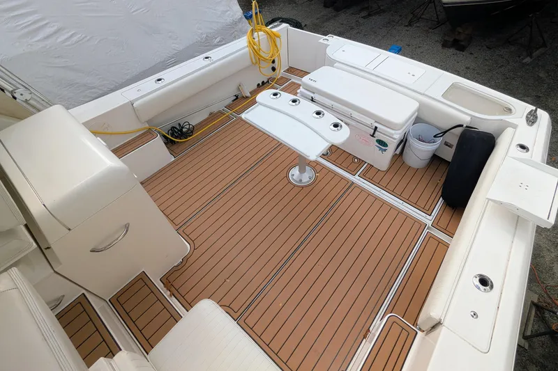 Slide: The Image of 2002 Stamas 340 Express boat deck with teak flooring, seating, and fishing rod holders. - 9