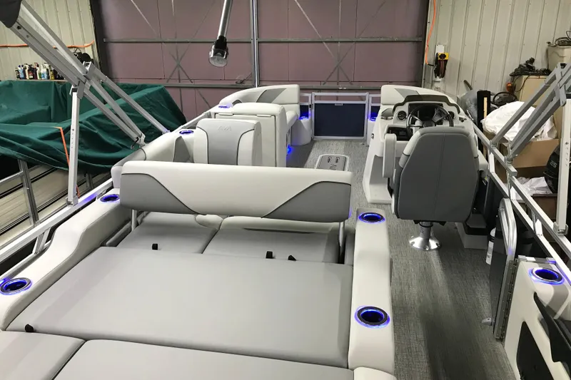 Slide: The Image of 2026 Avalon Venture 85 Versatile Rear Bench boat interior with modern seating and blue LED cup holders. - 17