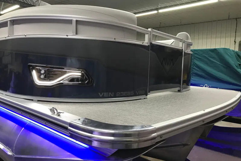 Slide: The Image of 2026 Avalon Venture 85 Versatile Rear Bench pontoon boat with sleek design and blue LED lighting. - 21