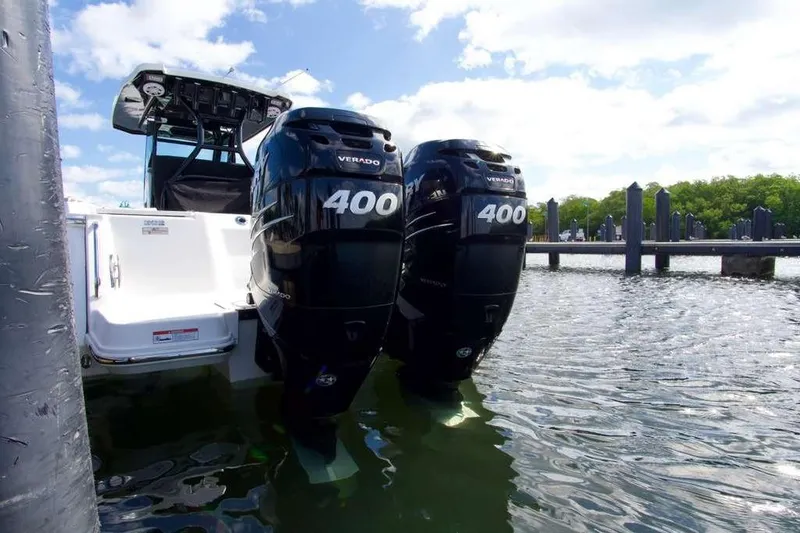 Slide: The Image of 2023 Blackfin 302 CC with dual 400 Verado engines docked in sunny marina. - 10