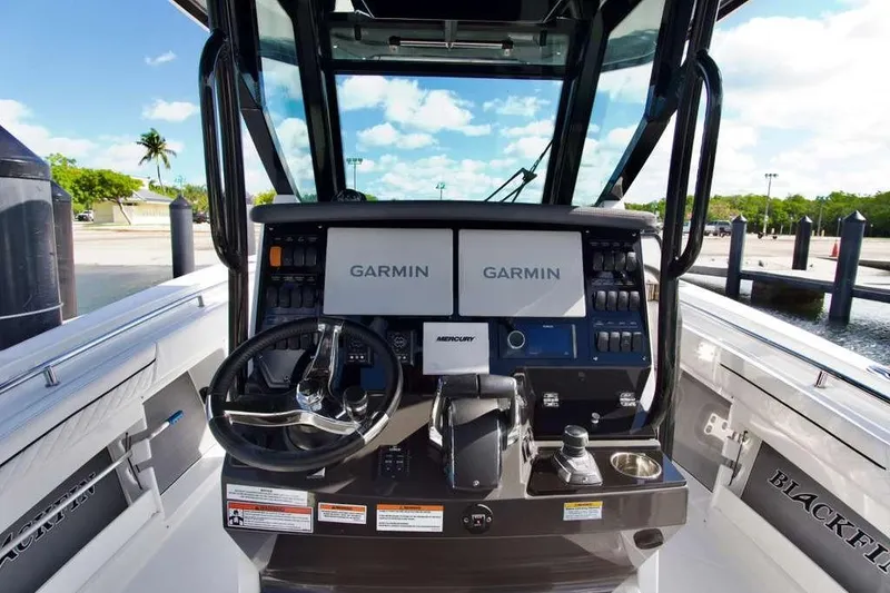 Slide: The Image of 2023 Blackfin 302 CC boat dashboard with Garmin displays and Mercury controls. - 11