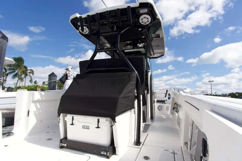 Slide: The Image of 2023 Blackfin 302 CC boat with Yeti cooler, under clear blue sky. - 14