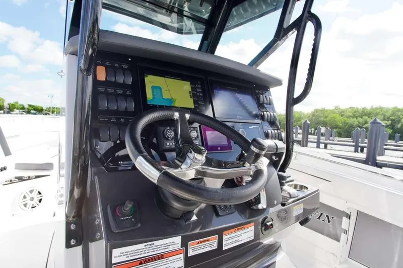 Slide: The Image of 2023 Blackfin 302 CC boat dashboard with steering wheel and navigation screens. - 18