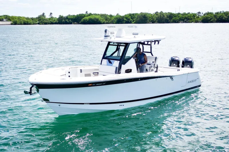 Slide: The Image of 2023 Blackfin 302 CC boat on clear water, featuring dual engines and sleek design. - 2