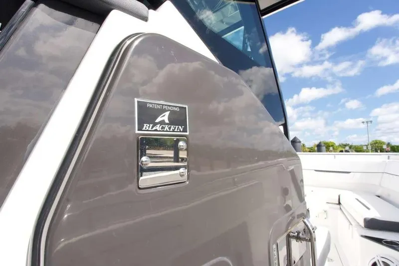 Slide: The Image of 2023 Blackfin 302 CC boat detail with logo, under a clear blue sky. - 29