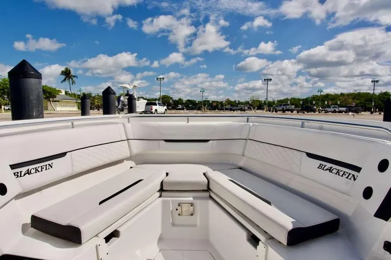 Slide: The Image of 2023 Blackfin 302 CC boat interior with white seating under a blue sky. - 30