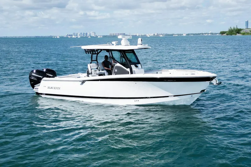 Slide: The Image of 2023 Blackfin 302 CC boat cruising on open water under a partly cloudy sky. - 7